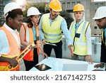 Small photo of We have a lot to get through. Shot of a diverse group of contractors standing outside together and having a discussion over building plans.