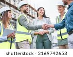 Small photo of When we strive to become better than we are. Shot of a team of builders shaking hands on a construction site outside.