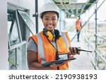 Small photo of Portrait of proud black construction worker leading with power while managing site logistics on tablet. Happy female engineer supervising a building project and inspection of architectural details