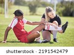 Small photo of Soccer, sports and injury of a female player suffering with sore leg, foot or ankle on the field. Painful, hurt and discomfort woman getting her pain checked out by athletic trainer on the pitch.