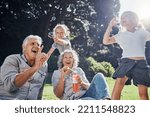 Grandparents, bubbles and children play in park happy together for fun, joy and outdoor happiness. Retired, smile and excited elderly senior couple, girl grandkids and love playing outside in nature