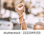 Hand, rope and fist protest slavery for freedom and human rights against an urban background. Activist, activism and rebellion against racism and change for civil, law and government rights
