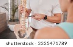 Small photo of Spine model, healthcare and chiropractor with woman for consultation or treatment advice. Physiotherapy, wellness and doctor with patient and skeleton explaining cause of back pain, injury or problem
