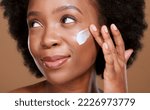 Small photo of Black woman, face cream and beauty, sunscreen makeup product and luxury facial treatment on studio background. Young african model, body lotion and cosmetics for healthy skincare, wellness and shine