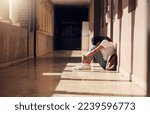 Small photo of Sad, lonely and girl with depression at school, crying and anxiety after bullying. Mental health, tired and unhappy student in the corridor after problem in class, education fail and social isolation