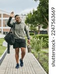 Small photo of Fitness, happy or black man walking to gym and wave for training, exercise or workout with a duffle bag in Miami, Florida. Smile, traveling or healthy sports athlete with goals, motivation or pride