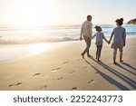 Black family, sunset and beach walk during summer on vacation relaxing at a peaceful scenery by the ocean. Sea, footprints and parents with daughter, child or kid with childhood freedom