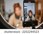 Small photo of Communication, phone and black woman streaming podcast, radio talk show or speaker talking about teen culture. Online broadcast microphone, ring light or gen z influencer speaking about student news