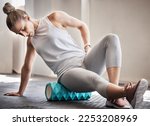 Pilates, physiotherapy and massage, woman with foam roller on floor for leg tension and support in yoga workout at gym. Health, fitness and massaging for sports physio, girl on ground rolling muscle.