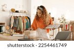 Small photo of Black woman, package check and fashion e commerce start up. Small business owner, online retail brand supplier and digital store supply chain delivery confirmation with laptop on store