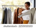 Small photo of Shopping, clothes and black woman for choice, wardrobe inspiration or retail design ideas in thrift store or boutique. Happy customer, student or person service in fashion discount, sale or promotion