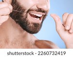 Small photo of Dental, floss and oral hygiene with a man in studio on a blue background cleaning his teeth for healthy gums. Dentist, healthcare and mouth with a young male flossing to remove plague or gingivitis