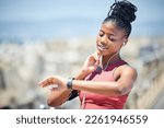 Heart rate, smartwatch and runner time of a black woman by the sea doing exercise and running. Outdoor, run tracker app and mobile of a athlete with headphones by the ocean listening to audio