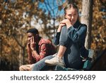 Small photo of Hiking, conflict and couple argue in a forest, annoyed and sad while sitting, lost and unhappy. Sad, woman and man arguing while hiking in nature, upset and angry, disappointment and breakup, trouble