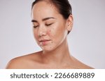 Small photo of Skincare, face and beauty of a woman in studio for cosmetic, dermatology and makeup shine. Aesthetic asian model person with wellness glow, mole on skin and luxury facial self care on grey background