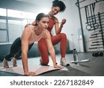 Personal trainer, fitness and stopwatch with a black woman coaching a client in a gym during her workout. Health, exercise or training and a female athlete doing a plank with her coach recording time