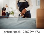 Small photo of Fashion designer and tailor cutting fabric and making or preparing pattern for stylish, trendy and fashionable clothes. Workshop or boutique seamstress using denim material or textile for edgy wear
