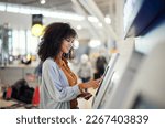 Black woman, airport and smile by self service station for ticket, registration or boarding pass. Happy African female traveler by kiosk machine for travel application, document or booking flight