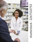 Small photo of This is what youre looking for. Shot of a cheerful young female pharmacist giving a customer prescription meds over the counter in a pharmacy.