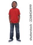 Small photo of Stylin little dude. A young African boy standing with his hands in his pockets smiling at the camera.