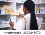 Pharmacy stock, woman and medicine check of a customer in a healthcare and wellness store. Medical, inventory and pharmaceutical label information checking of a black female person back by shop shelf