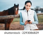Small photo of I cant wait to post this. an attractive woman using her cellphone while posing with a horse in an enclosed pasture on a farm.