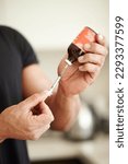 Small photo of Man, filling a syringe or liquid injection of testosterone and bottle, steroids and closeup of bodybuilder hands. Athlete, fitness performance on hormone supplement and medicine vial with needle