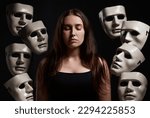 Small photo of Im in control of my own emotions. Studio shot of a woman standing with her eyes closed while surrounded by masks.