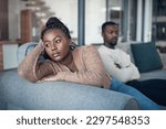 I dont want to hear anything he has to say. a young couple sitting on the sofa and giving each other the silent treatment after an argument.