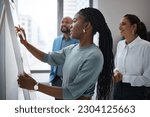 Black woman, business writing and office whiteboard for company planning with strategy. African female employee, meeting and sales collaboration of staff working with teamwork and workshop idea
