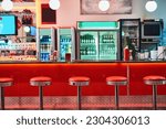 Small photo of Retro, vintage and stools with interior in a diner, restaurant or cafeteria with funky decor. Trendy, old school and chairs by a counter or bar in groovy, vibrant and stylish old fashioned empty cafe