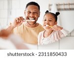 Child, dad and brushing teeth in a family home bathroom for dental health and wellness in a mirror. Face of african man and girl kid learning to clean mouth with toothbrush and smile for oral hygiene