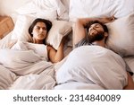 Small photo of Bedroom, snore and couple sleep, frustrated and woman angry over snoring, problem and morning noise. Sleeping, home insomnia and relax girl with fatigue, tired and sleepless in apartment bed
