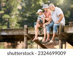 Dad, grandfather and teaching child fishing at lake together for fun bonding, lesson or activity in nature. Father, grandpa and kid learning to catch fish with rod by water pond or river in forest