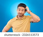Small photo of Portrait, head scratch and man confused over question, doubt or uncertain about problem crisis, error or decision. Studio, face and Asian male person unsure about choice isolated on blue background
