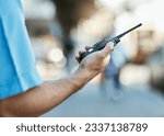 Small photo of Hand, walkie talkie and a security guard or safety officer outdoor on a city road for communication. Closeup of person with a radio on urban street to report crime for investigation and surveillance