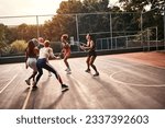 Small photo of Trying to get through. Cropped shot of a diverse group of sportswomen playing a competitive game of basketball together during the day.