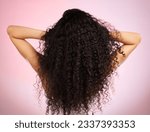 Hair, beauty and back of woman with hairstyle transformation and curly texture. Model, salon treatment and haircut shine in a studio with pink background and cosmetics with keratin and growth care