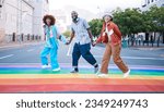 Small photo of Lgbtq, people holding hands and rainbow on street, paint and community with gen z, happiness and fashion in city. Urban streetwear, pride and queer support with ally, different or unique in portrait