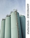 Small photo of Silo storage tankers against a gray sky in Danish oil industry. large oil plant storage tanks for export in industrial area. Silo tankers for keeping bulk food products, substances and materials safe