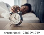 Wake up, alarm clock or woman sleeping in bed in the morning after resting pressing a snooze button. Sleepy blur, hand or tired person at home getting up from nap in bedroom ready to start a new day