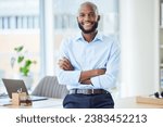 Confident business man standing with arms crossed in an office, looking proud and happy alone at work. Portrait of a smiling, cheerful and professional African male boss working in corporate
