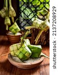 Small photo of Close up view of Ketupat, an Indonesian traditional cuisine very popular during Hari Raya Idul Fitri served on a wooden table. This is made of the white rice, usually served with opor ayam on Ied day.