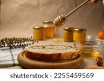 A slice of bread with honey. Rural or country breakfast - bread rolls, honey jar, nuts and tangerines