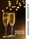 Small photo of 2024 image with two glasses of frosted Champaign against a soft party light bokeh background. Selective focus on the right hand frosted glass. 2024 new year concept.