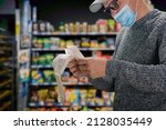 Small photo of Man in face mask shopping in grocery department store during coronavirus crisis
