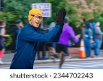 Small photo of Young friendly sporty man jogging on city street and greeting sportsmen and audience, Youthful amiable athlete running on urban road, extending greetings to fellow sports enthusiasts and spectators.
