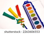 Small photo of TEMPERA TUBES AND WATERCOLOR TABLETS ON WHITE BACKGROUND. COLOR PHOTOGRAPHY. HORIZONTAL.