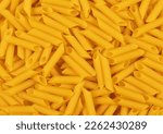 Small photo of Raw pene pasta in a random arrangement.