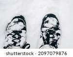 Closeup of hiking boots in the snow.